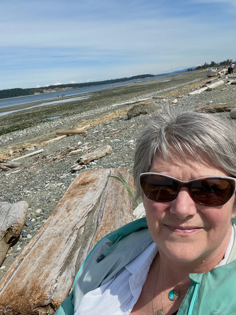 Woman with necklaces and beach in background