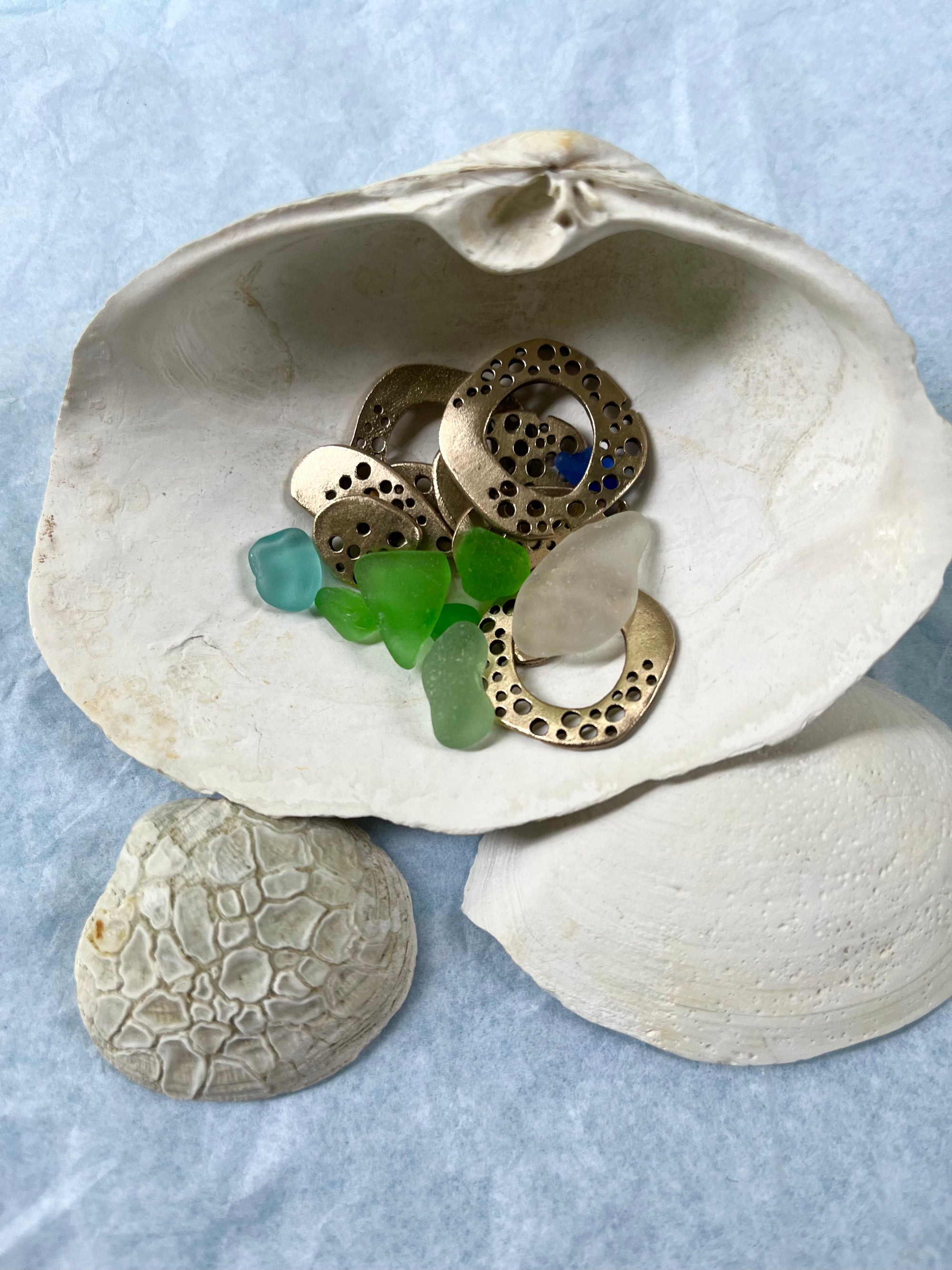 Beach glass with bronze pieces and seashells