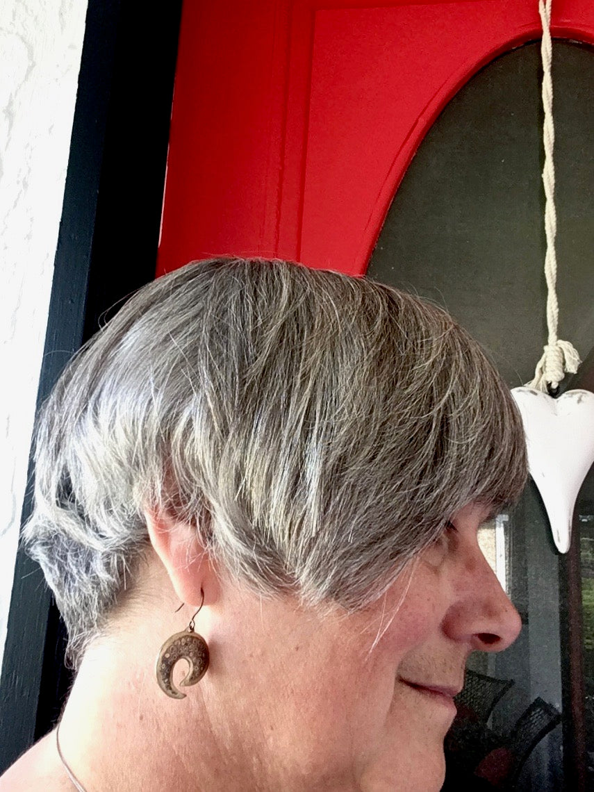 Patterned metal earrings in front of the red door